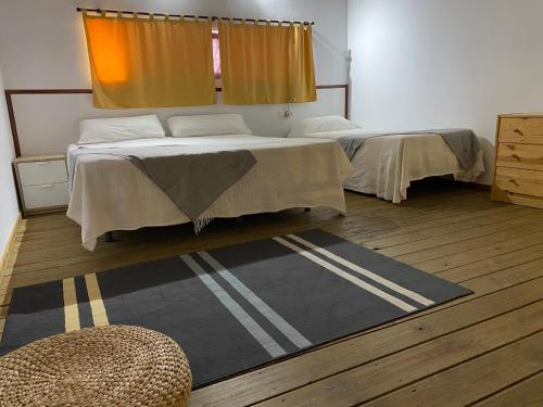 een slaapkamer met 2 bedden en een tapijt bij Casa Rural Coripe in Coripe