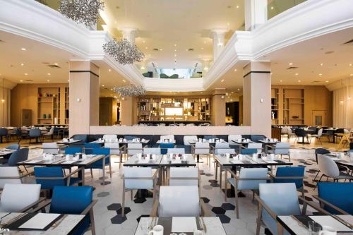 - une vue sur un restaurant avec des tables et des chaises dans l'établissement Hilton Malta, à San Ġiljan
