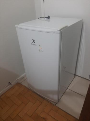 a white refrigerator in a room with a wooden floor at Quartos Aconchegantes prox Pelourinho, Metrô e Arena F Nova in Salvador