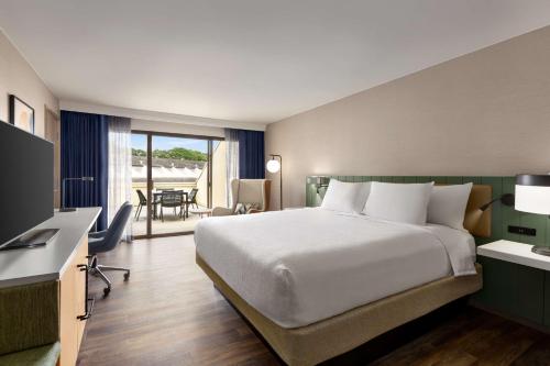 a hotel room with a bed and a television at Hilton Garden Inn Monterey in Monterey