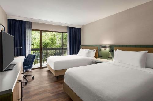 a hotel room with two beds and a television at Hilton Garden Inn Monterey in Monterey
