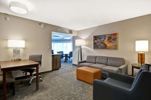 een woonkamer met een bank en een tafel bij Embassy Suites by Hilton Minneapolis Airport in Bloomington