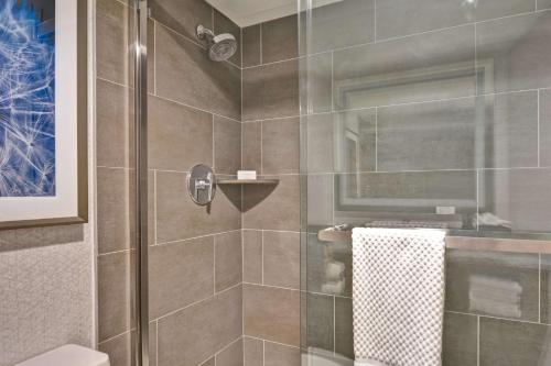 a bathroom with a shower with a glass door at Embassy Suites by Hilton Minneapolis Airport in Bloomington