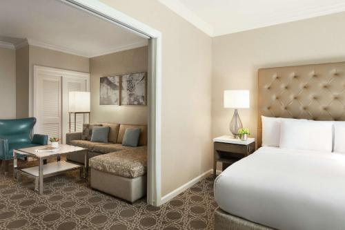 a bedroom with a bed and a living room at Hilton New Orleans / St. Charles Avenue in New Orleans