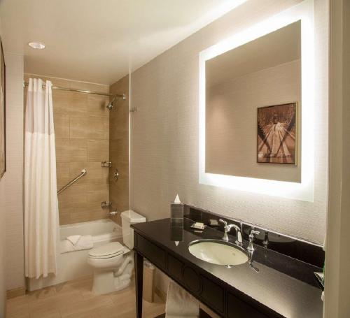 a bathroom with a sink and a toilet and a mirror at Hilton New Orleans / St. Charles Avenue in New Orleans