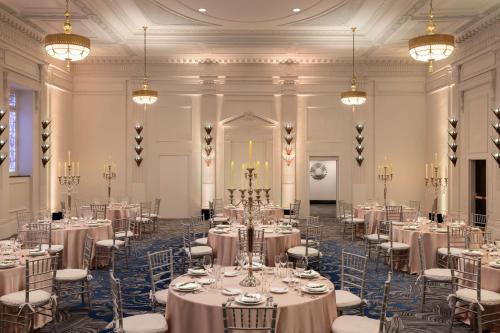 a banquet hall with tables and chairs and chandeliers at Hilton New Orleans / St. Charles Avenue in New Orleans