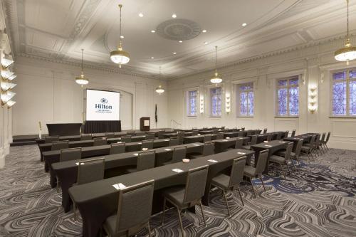 a room with a lecture hall with tables and chairs at Hilton New Orleans / St. Charles Avenue in New Orleans