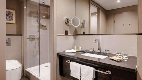 a bathroom with a sink and a shower and a toilet at Hilton Munich City in Munich