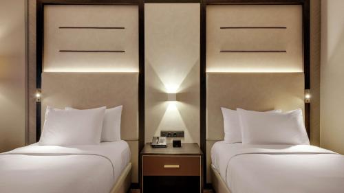 two beds sitting next to each other in a room at Hilton Munich City in Munich