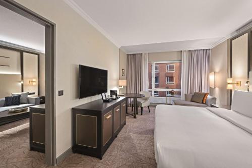 a hotel room with a bed and a television at Hilton Munich City in Munich