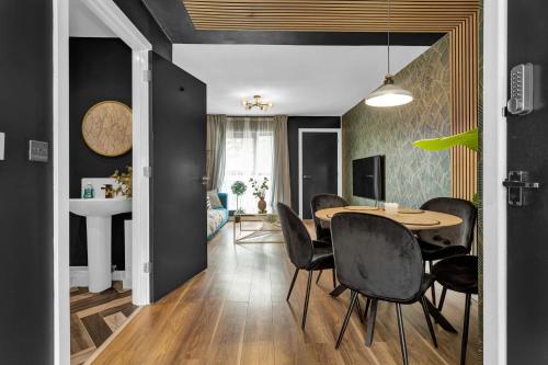 a dining room with a table and black walls at Free Parking Luxury Safari House in Manchester