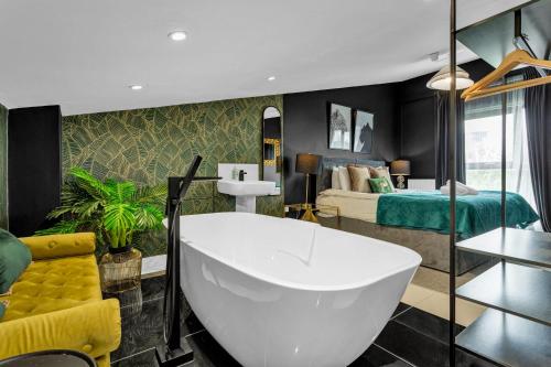 a bathroom with a white tub and a bedroom at Free Parking Luxury Safari House in Manchester