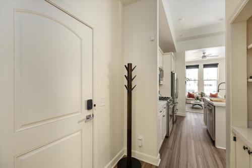 a hallway with a white door and a kitchen at The Lumber Baron's Mansion: 2 King Suites, 2.5BA + Gym in Detroit