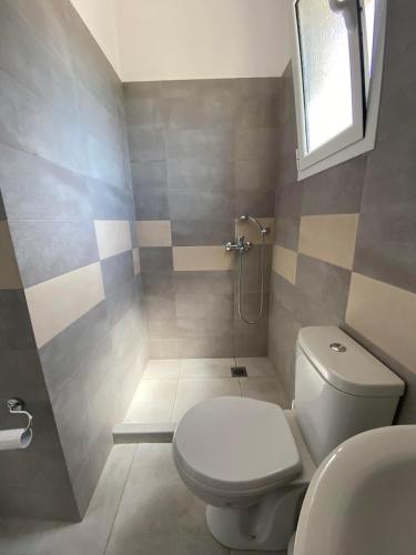 a bathroom with a toilet and a sink at Penelope & Michael Rooms in Himare