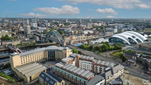 une vue aérienne sur une ville avec une rivière et des bâtiments dans l'établissement Hilton Newcastle Gateshead, à Newcastle upon Tyne