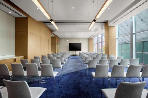 a conference room with chairs and a screen at Conrad New York Downtown in New York