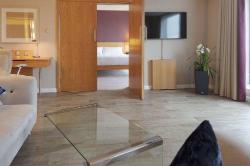 a living room with a couch and a room with a bedroom at Hilton Newcastle Gateshead in Newcastle upon Tyne