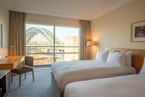 a hotel room with two beds and a view of the roller coaster at Hilton Newcastle Gateshead in Newcastle upon Tyne