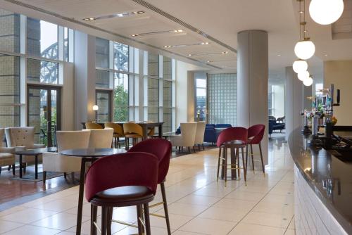 a restaurant with tables and chairs and windows at Hilton Newcastle Gateshead in Newcastle upon Tyne