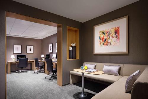 a waiting room with a couch and desks and chairs at Conrad New York Downtown in New York