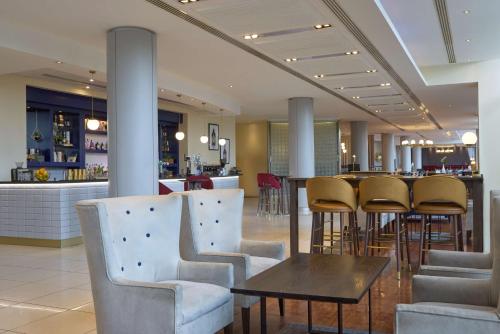 a restaurant with chairs and a table and a bar at Hilton Newcastle Gateshead in Newcastle upon Tyne