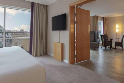 a hotel room with a bed and a flat screen tv at Hilton Newcastle Gateshead in Newcastle upon Tyne