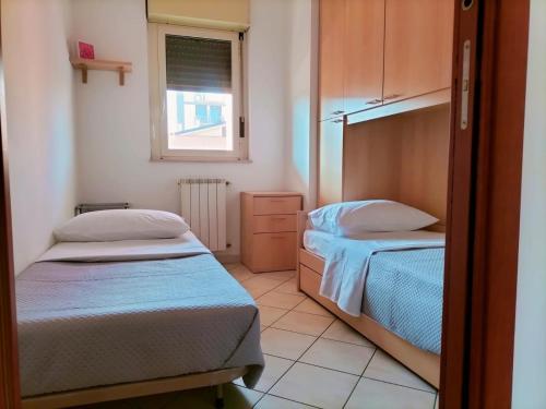 a small bedroom with two beds and a window at Appartamento Solaris 200 m dal mare in San Salvo