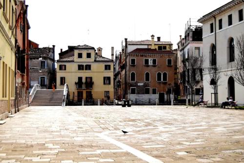 een lege straat met gebouwen en een vogel op de grond bij Campo San Lorenzo in Venetië