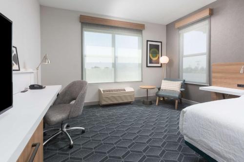 聖萊安德羅的住宿－奧克蘭/聖林德羅希爾頓花園旅館，酒店客房,配有一张床、一张桌子和椅子