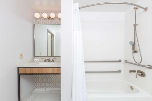 聖萊安德羅的住宿－奧克蘭/聖林德羅希爾頓花園旅館，白色的浴室设有浴缸和水槽。