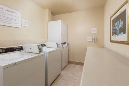 a kitchen with a refrigerator and a washer and dryer at Hilton Garden Inn Oakland/San Leandro in San Leandro