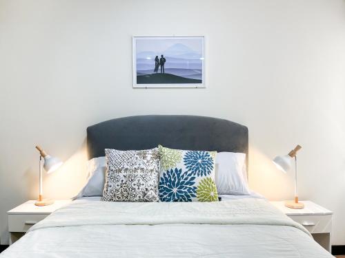 a bedroom with a bed with pillows and two lamps at Sky Suites - Incredible 2 Bedroom Apartment in La Paz in La Paz