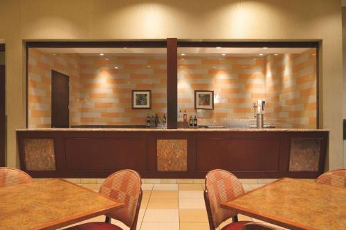 a restaurant with tables and chairs and a bar at Embassy Suites by Hilton Norman Hotel & Conference Center in Norman