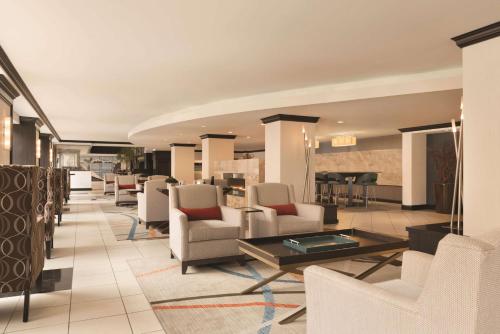 a lobby with white chairs and a table at Hilton Orrington/Evanston in Evanston