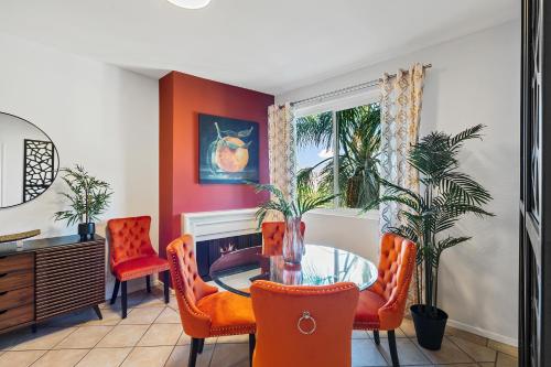 ein Esszimmer mit orangefarbenen Stühlen und einem Glastisch in der Unterkunft Beverly Hills 2 bed 2 bath Penthouse with Den and Parking 414 in Los Angeles