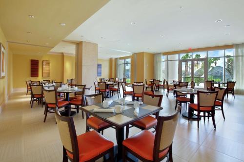a dining room with tables and chairs and windows at Signia by Hilton Orlando - An Official Walt Disney World Hotel in Orlando