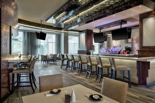 a restaurant with tables and chairs and a bar at Signia by Hilton Orlando - An Official Walt Disney World Hotel in Orlando