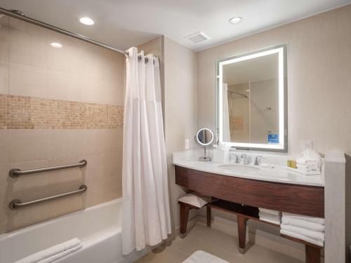 a bathroom with a tub and a sink and a mirror at Signia by Hilton Orlando - An Official Walt Disney World Hotel in Orlando