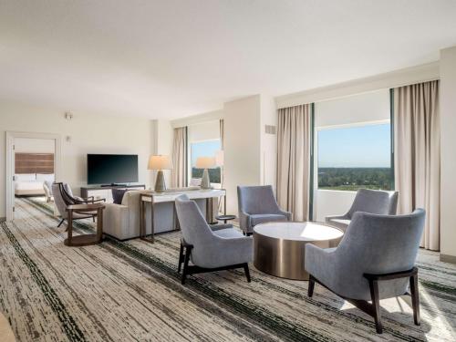 a hotel room with chairs and a table and a television at Signia by Hilton Orlando - An Official Walt Disney World Hotel in Orlando