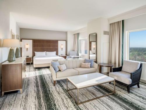 um quarto de hotel com uma cama king-size e uma sala de estar em Signia by Hilton Orlando Bonnet Creek em Orlando