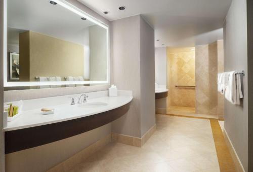 a bathroom with a sink and a mirror and a shower at Signia by Hilton Orlando - An Official Walt Disney World Hotel in Orlando