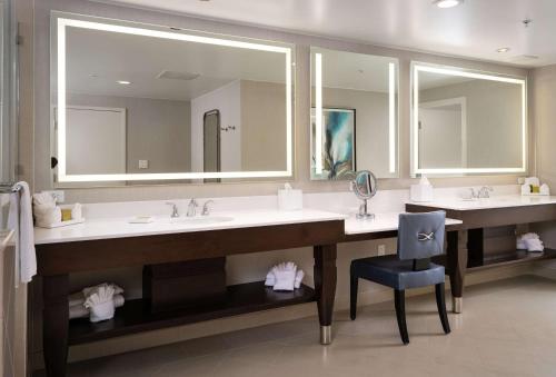 a large bathroom with two sinks and a blue chair at Signia by Hilton Orlando - An Official Walt Disney World Hotel in Orlando
