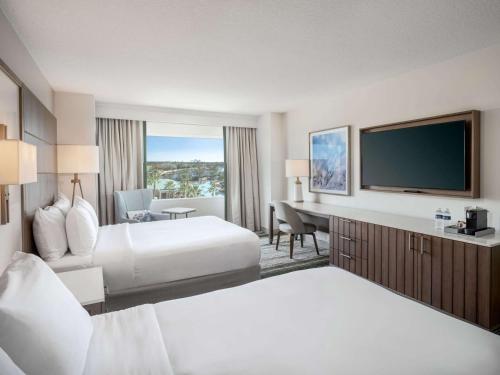 a hotel room with two beds and a flat screen tv at Signia by Hilton Orlando - An Official Walt Disney World Hotel in Orlando