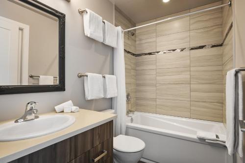 a bathroom with a sink and a toilet and a tub at SoLo Suites in Victoria