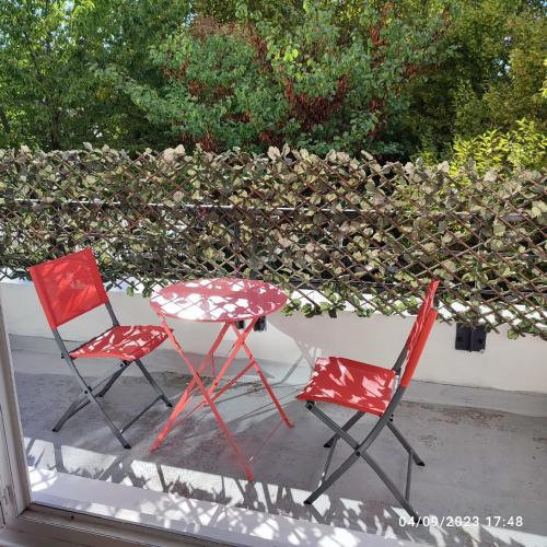 - deux chaises et une table sur une terrasse couverte dans l'établissement BIG logement , JO2024, stade de France, PARIS, métro , parking gratuit, à Saint-Denis