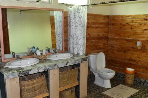 Kisoro的住宿－Bwindi Orugano Lodge，一间带两个盥洗盆和卫生间的浴室