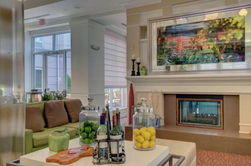 a living room with a couch and a fireplace at Hilton Garden Inn Norwalk in Norwalk