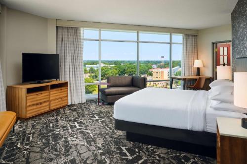 a hotel room with a bed and a flat screen tv at Embassy Suites by Hilton Hampton Convention Center in Hampton