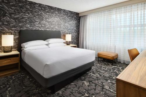 a hotel room with a bed and a large window at Embassy Suites by Hilton Hampton Convention Center in Hampton