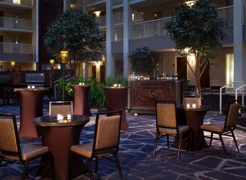 a hotel patio with tables and chairs and a bar at Embassy Suites by Hilton Philadelphia Airport in Philadelphia